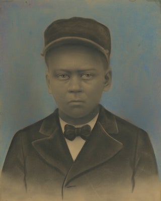 Item #52389 HAUNTING HAND-COLORED PORTRAIT OF A YOUNG AFRICAN-AMERICAN IN A PULLMAN PORTER UNIFORM