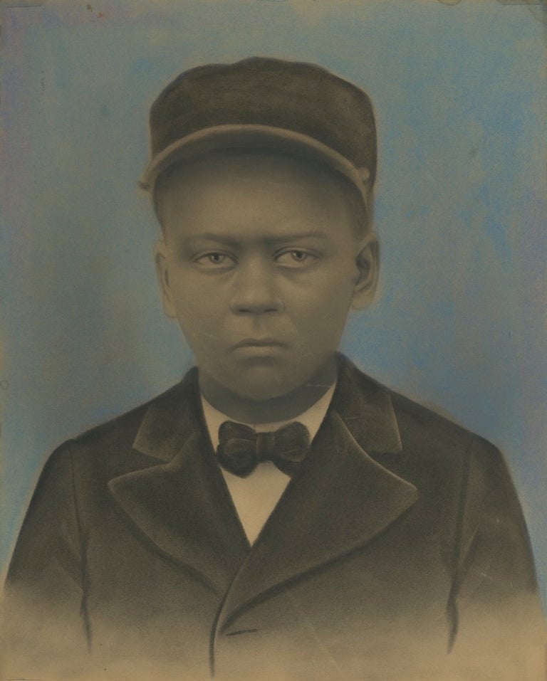 Item #52389 HAUNTING HAND-COLORED PORTRAIT OF A YOUNG AFRICAN-AMERICAN IN A PULLMAN PORTER UNIFORM.